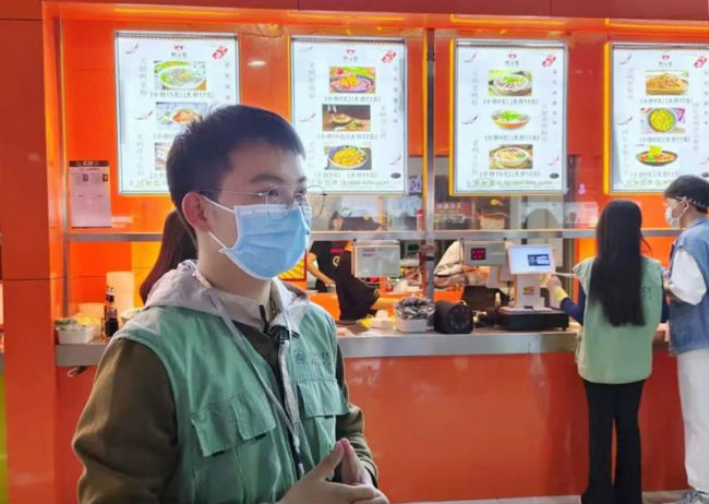 志愿者在领取免费的爱心老鸭汤粉丝